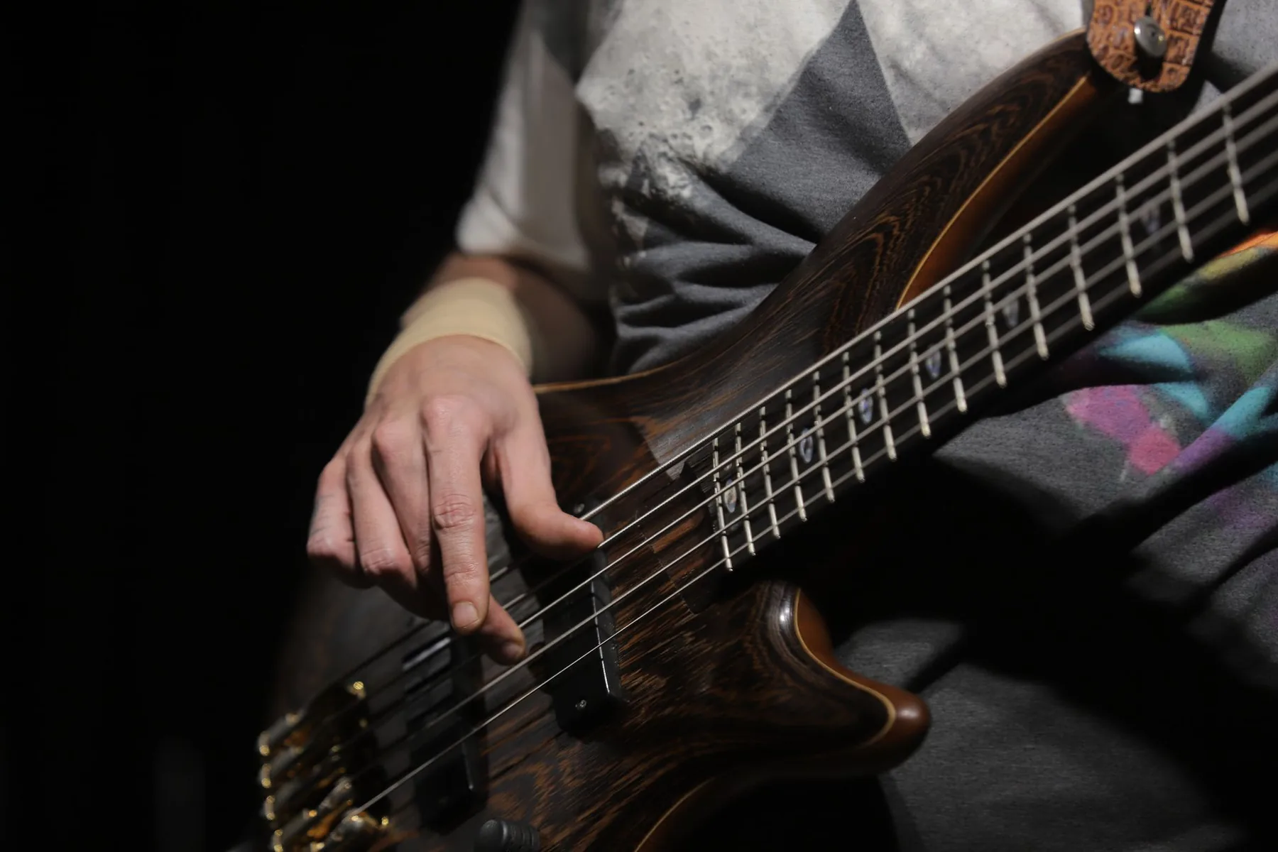 Bassist playing on a dark stage Bassist playing on a dark stage